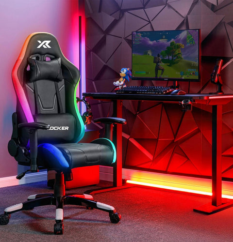 Gaming setup with a chair, desk, and computer monitor in a room with geometric wall design.