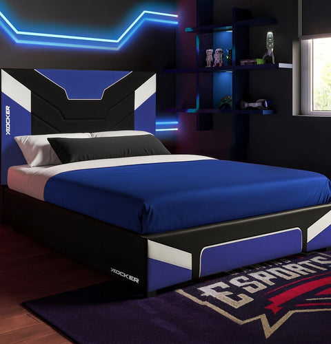 Bedroom with a bed featuring a blue and black color scheme, illuminated by neon lights.